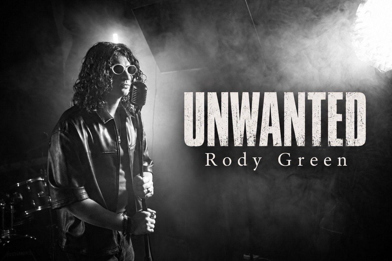 Black-and-white promotional image of Rody Green wearing sunglasses and holding a vintage microphone amid smoke, with “UNWANTED” and “Rody Green” written beside him.